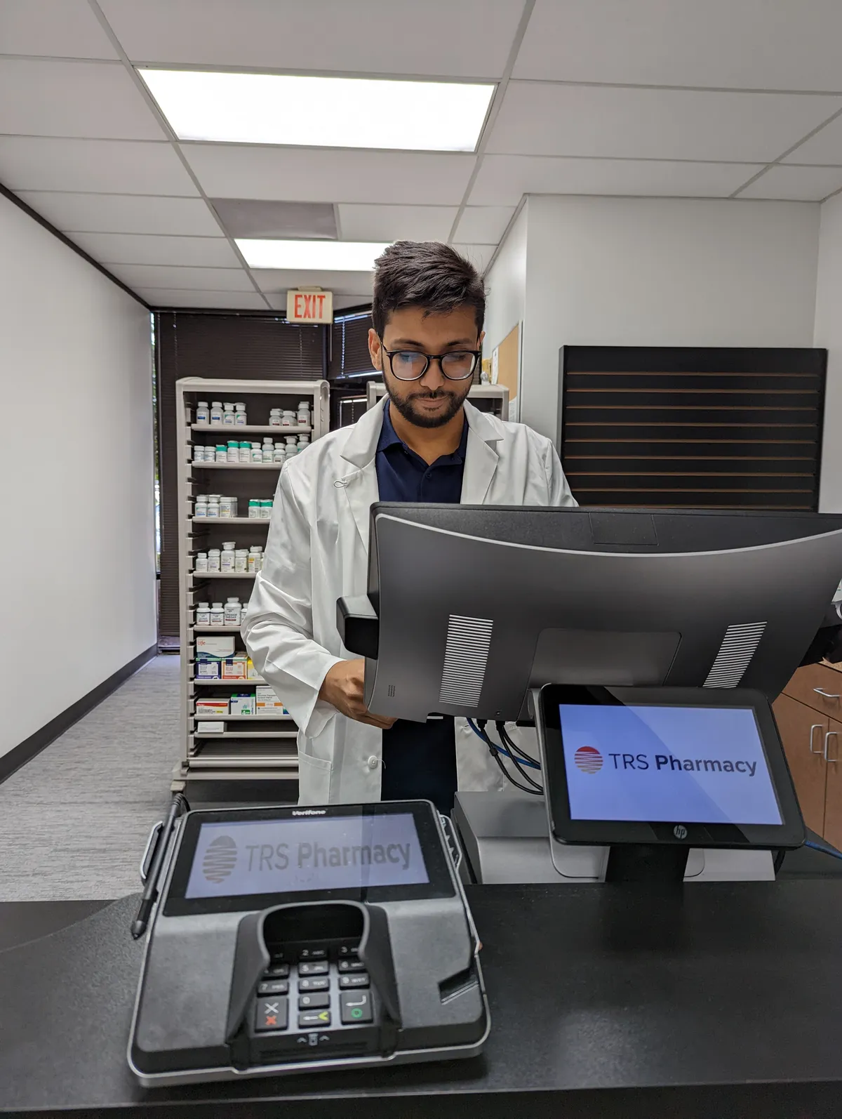 Dr. Haroon Waseem at the TRS Pharmacy dispensing counter in Stafford, TX
